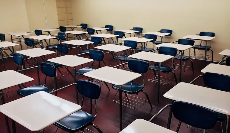 Rows of empty desks and chairs in a classroom