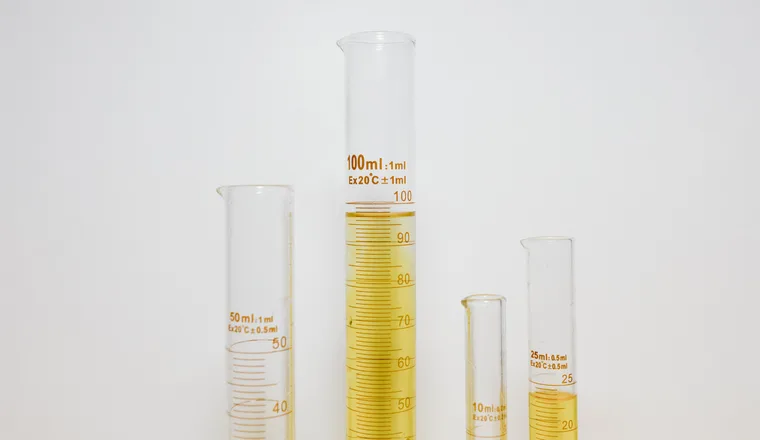 Graduated cylinders of coloured liquid on a laboratory bench